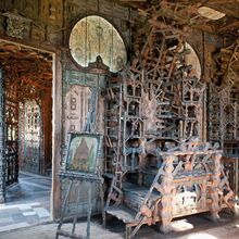 Foto des Inneren des Junkerhauses. Türen, Wände und Treppen scheinen nur aus Holz zu bestehen. Alles ist kunstvoll und filigran geschnitzt. Holzstäbe bilden teils kunstvolle Gerüste, durch die Licht fällt, das Holz trägt sanfte natürliche Farbe.