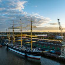 Sonnenaufgang im Hafen, in dem der Frachtsegler Peking vor Anker liegt. Es ist ein vier Masten tragendes Schiff mit insgesamt 32 Segeln, die eingeholt sind.