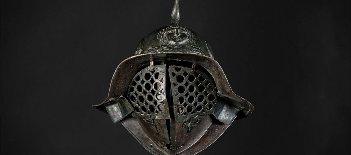 Foto eines historischen Stahlhelms auf schwarzem Hintergrund.