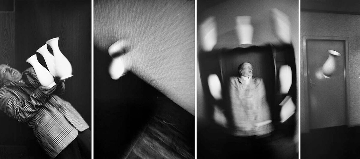 Vier schwarz-weiß Fotos im Hochformat bilden eine Kollage. Von links: Ein zurückgebeugter Mann balanciert drei gleiche Vasen auf den Händen, eine Vase von oben verwackelt, der Mann scheint mit Vasen zu jonglieren verwackelt, zwei im Raum schwebende Vasen.