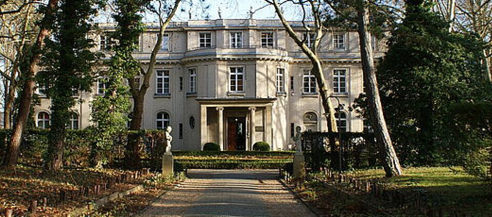Foto der Villa Marlier, ein prunkvolles Gebäude in einem Park. Der Eingangsbereich ist ein runder Vorbau mit Säulen und einem Balkon.