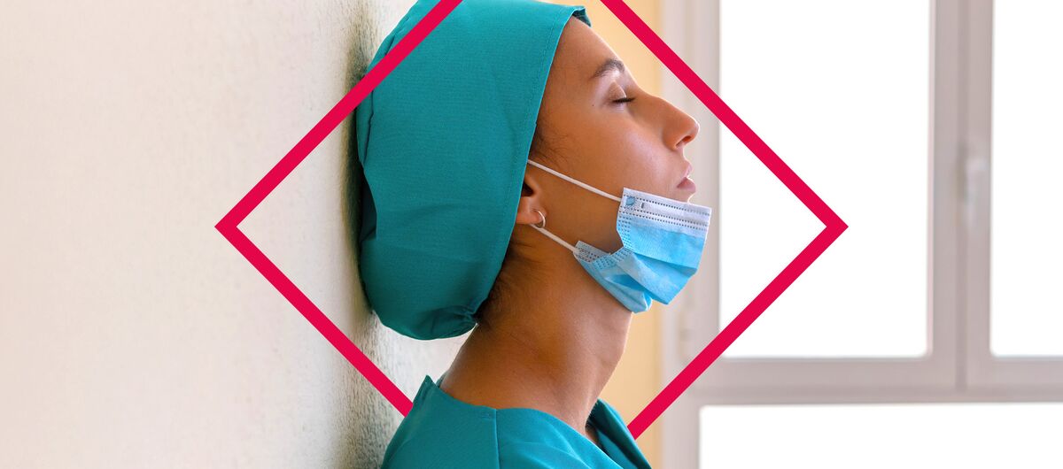 Seitliche Portraitaufnahme einer Frau, die mit geschlossenen Augen an der Wand lehnt. Sie trägt ein türkisefarbenes Oberteil und eine Kopfbedeckung in der gleichen Farbe. Eine OP-Maske ist auf ihr Kinn heruntergezogen.